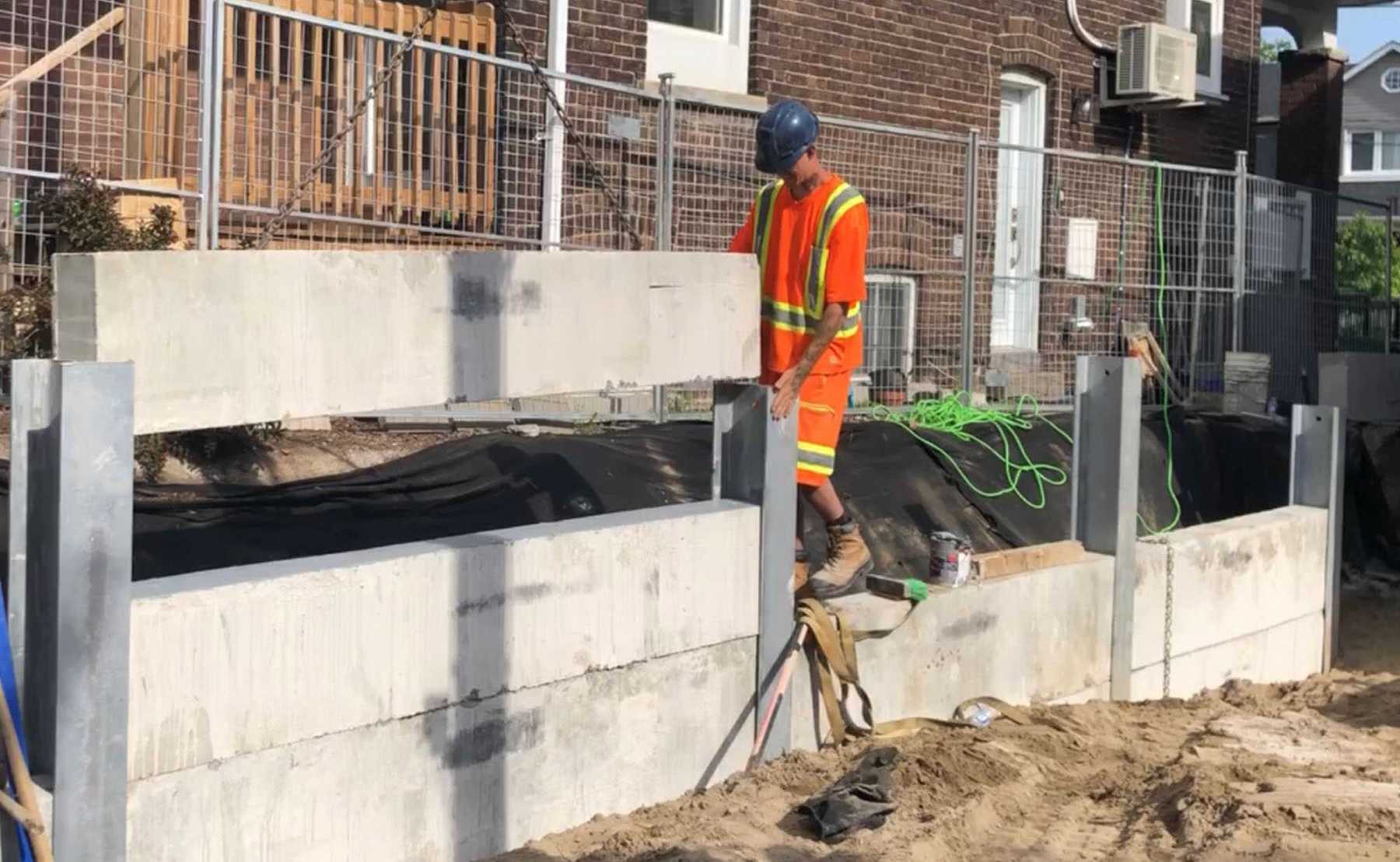 Constructing precast concrete panel retaining wall. Toronto, Ontario.