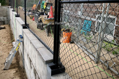 Chain link fence on top of the soldier pile and precast concrete panel retaining wall. Toronto, Ontario.