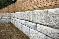 6’ high precast concrete block, retaining wall with pressure-treated fence on top. Toronto, Ontario.