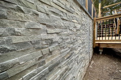 Soldier pile and precast concrete panel retaining wall beside a deck. Burlington, Ontario.