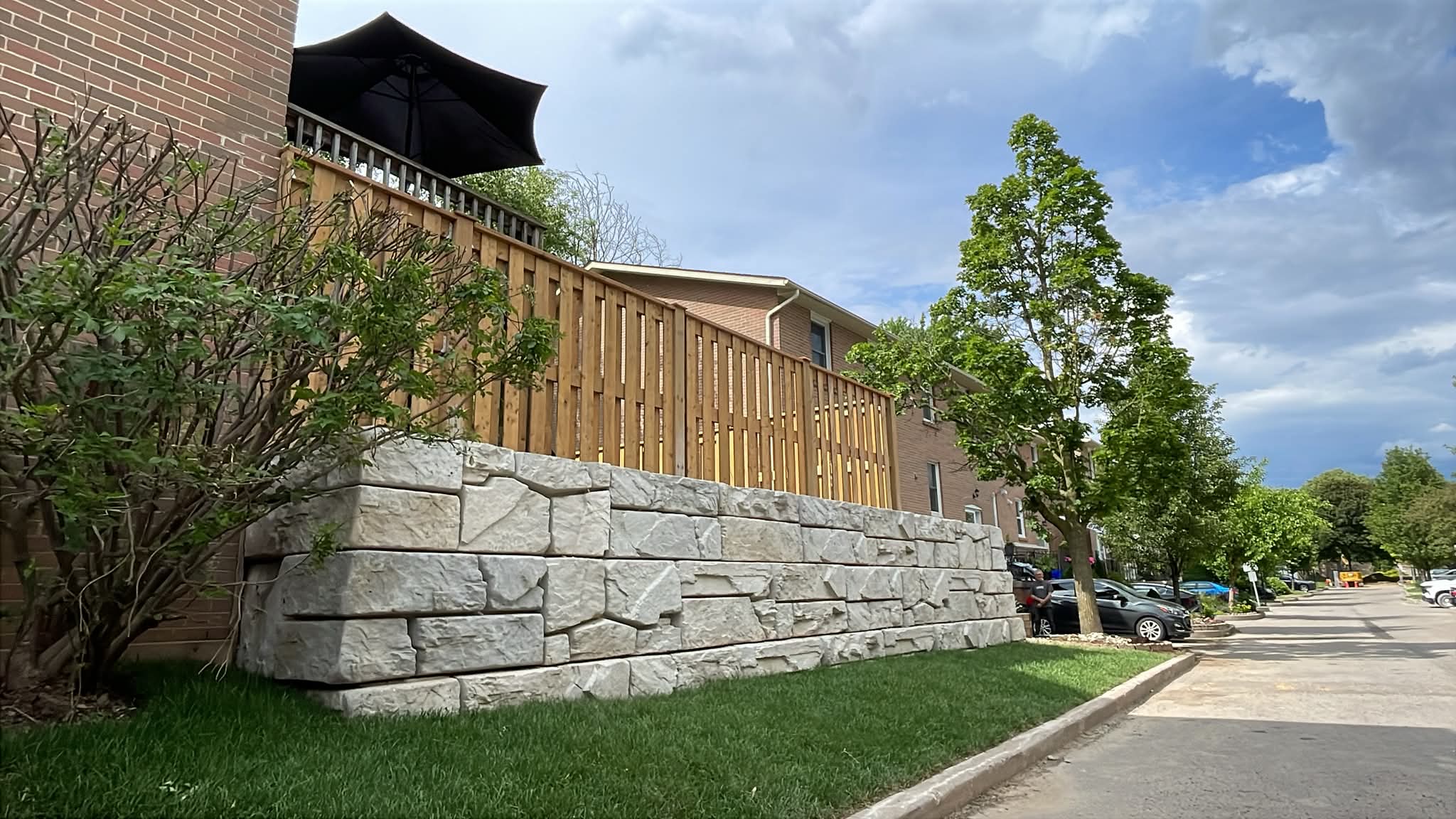 Stone retaining wall with lawn and sidewalk