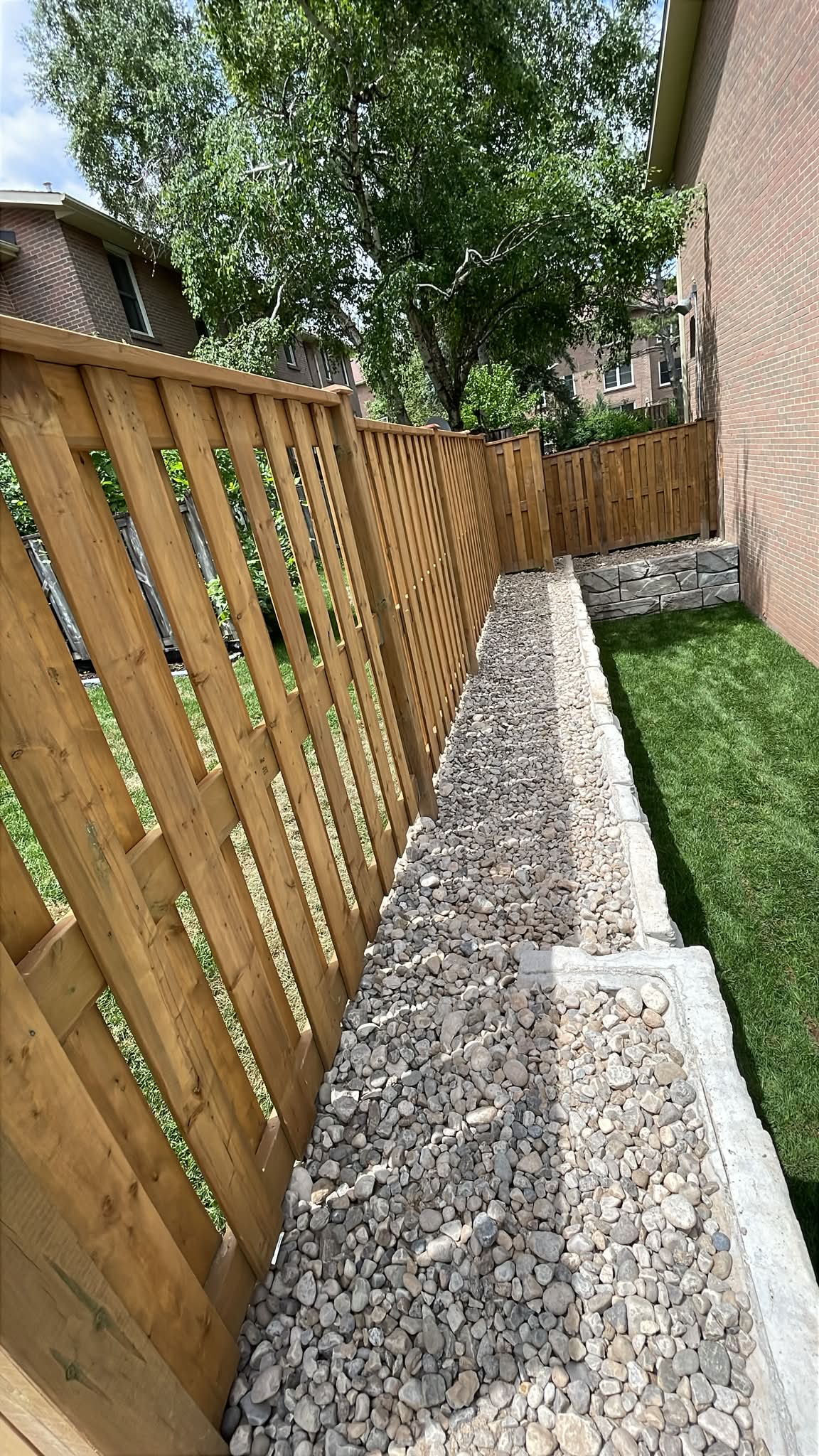 Narrow side yard with wooden fence and gravel