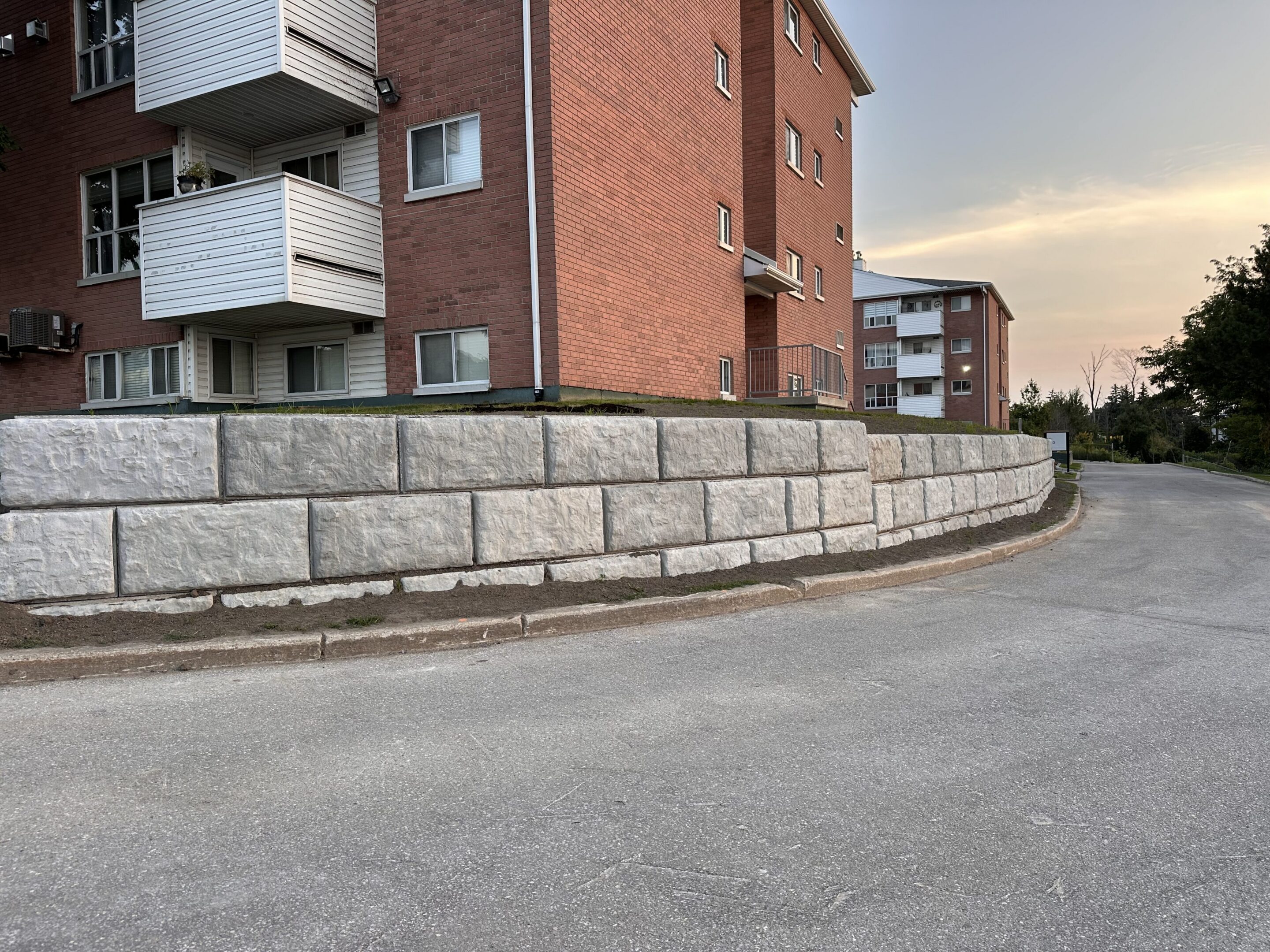 Apartment building with curved road and retaining wall