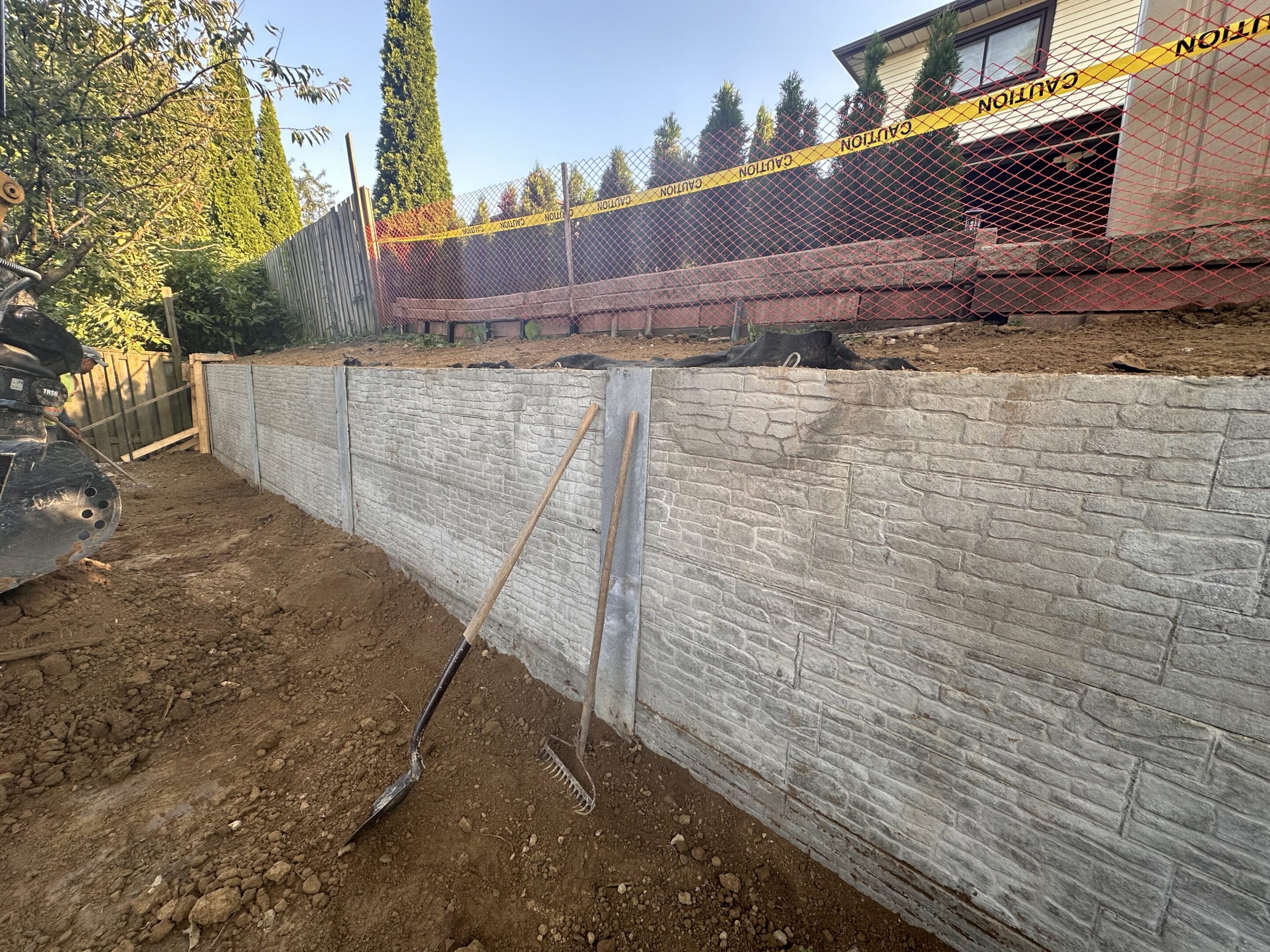 Stamped concrete retaining wall with shovel and rake