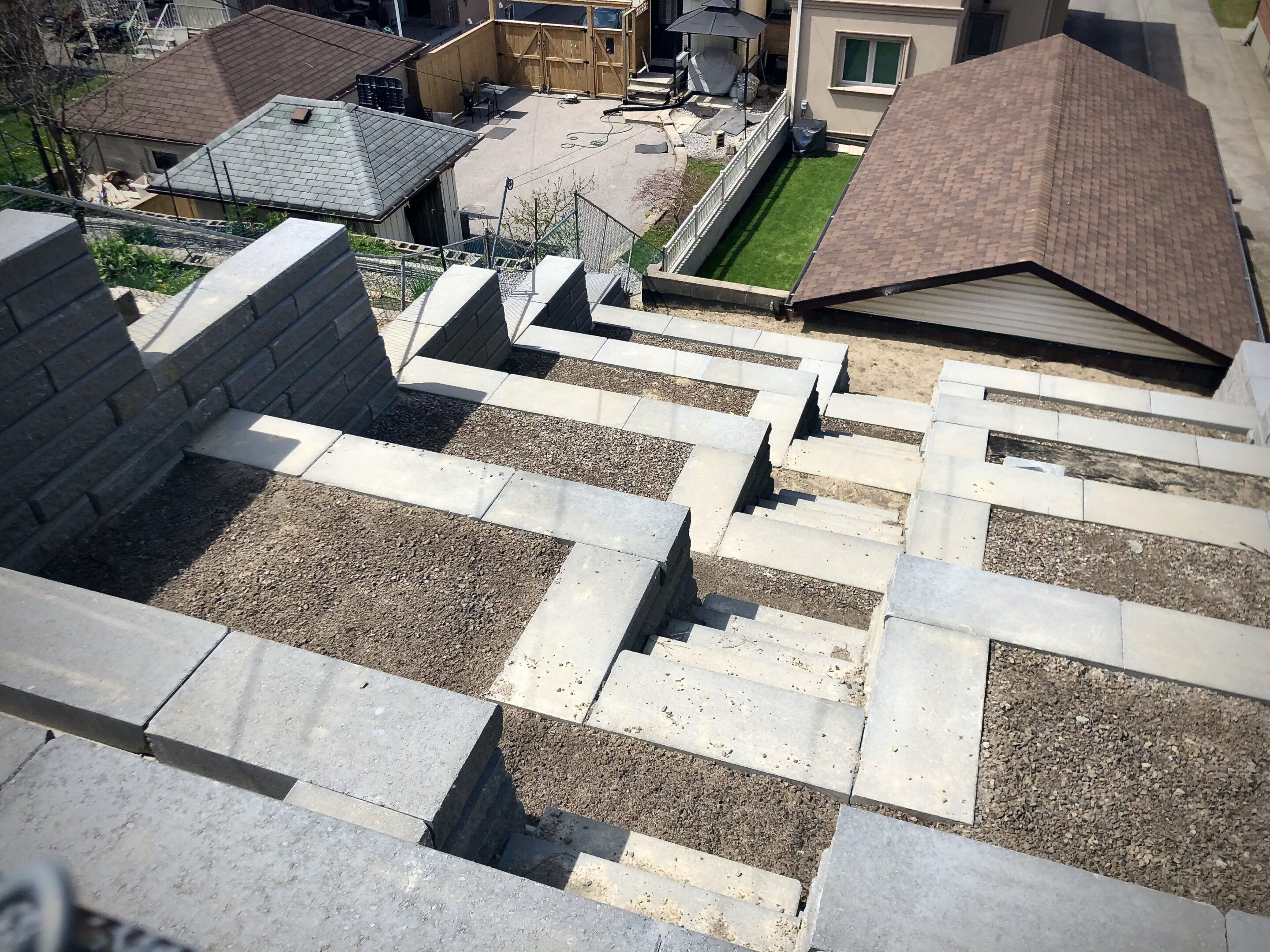 Stepped concrete retaining wall in residential backyard