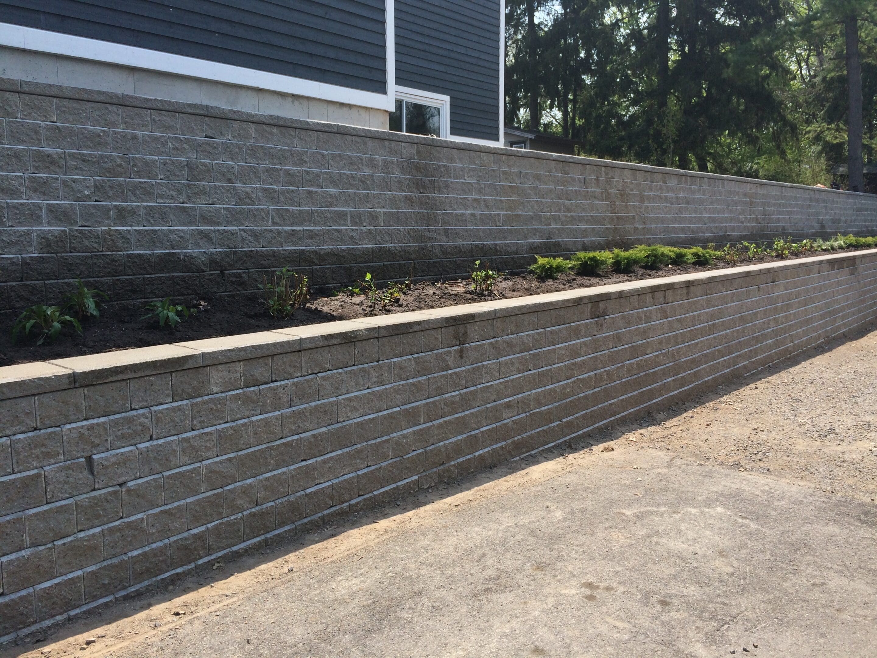 Two-tiered stone retaining wall with plantings
