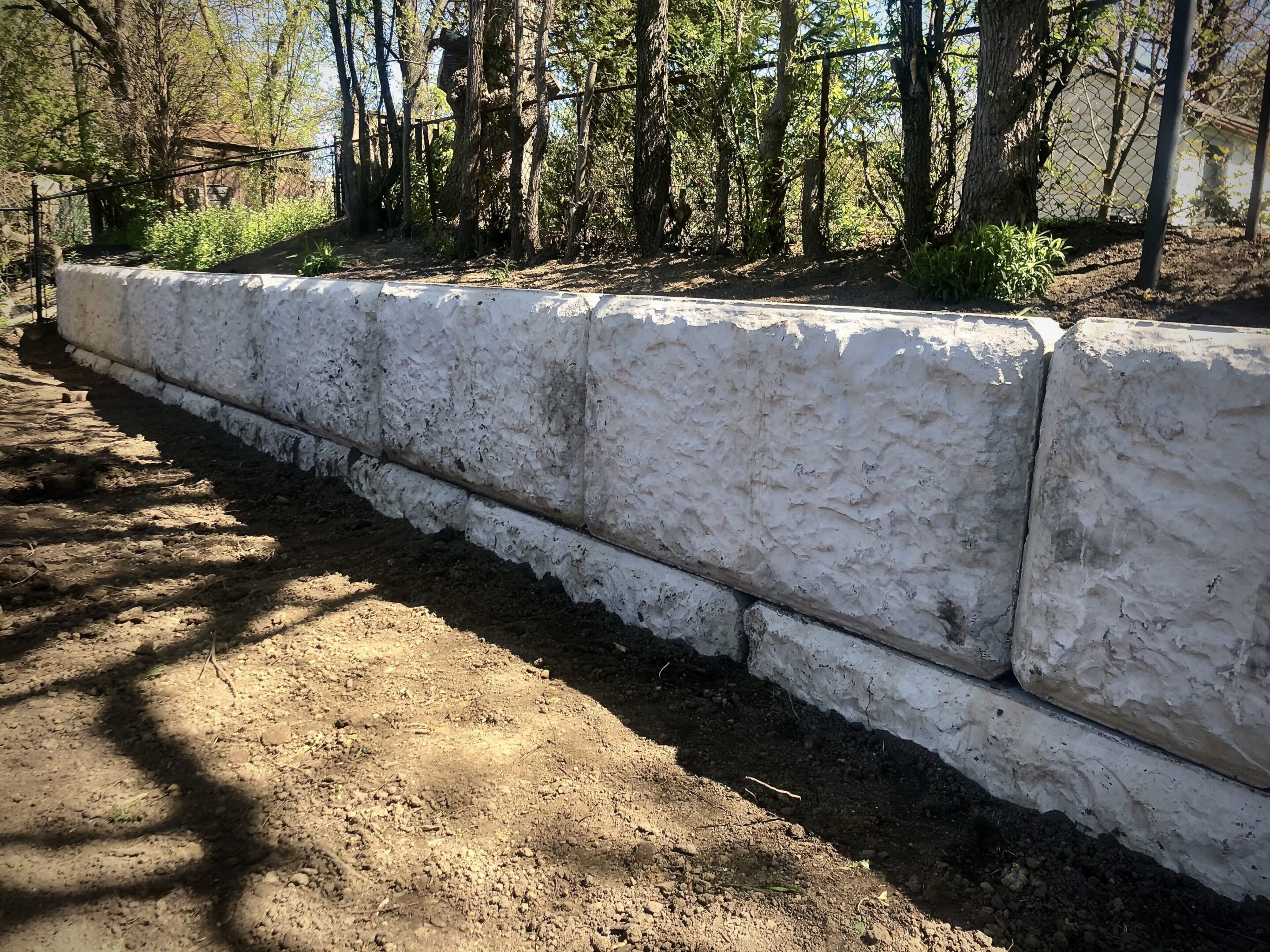 White concrete retaining wall along garden slope