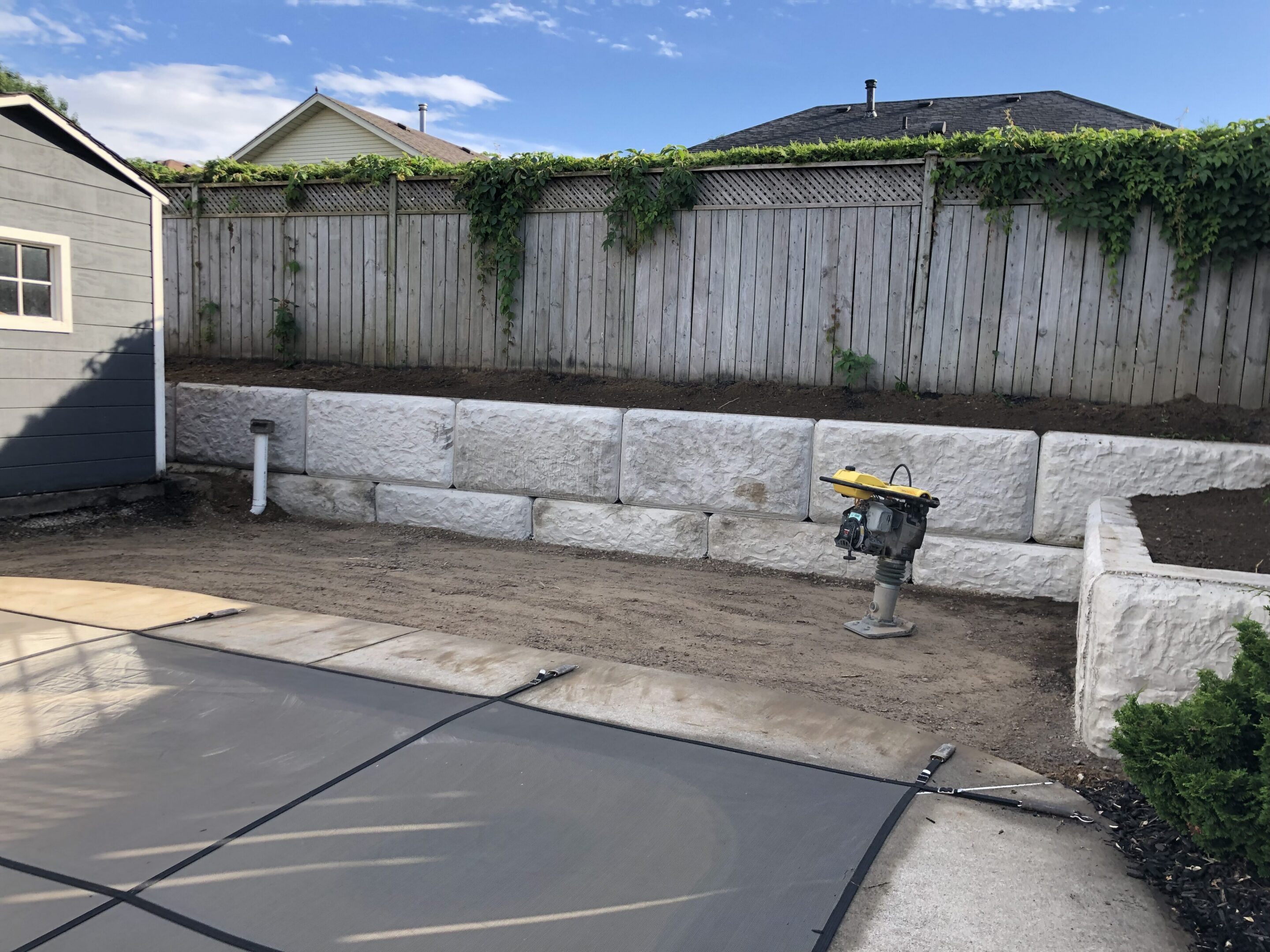 Backyard stone retaining wall with compactor