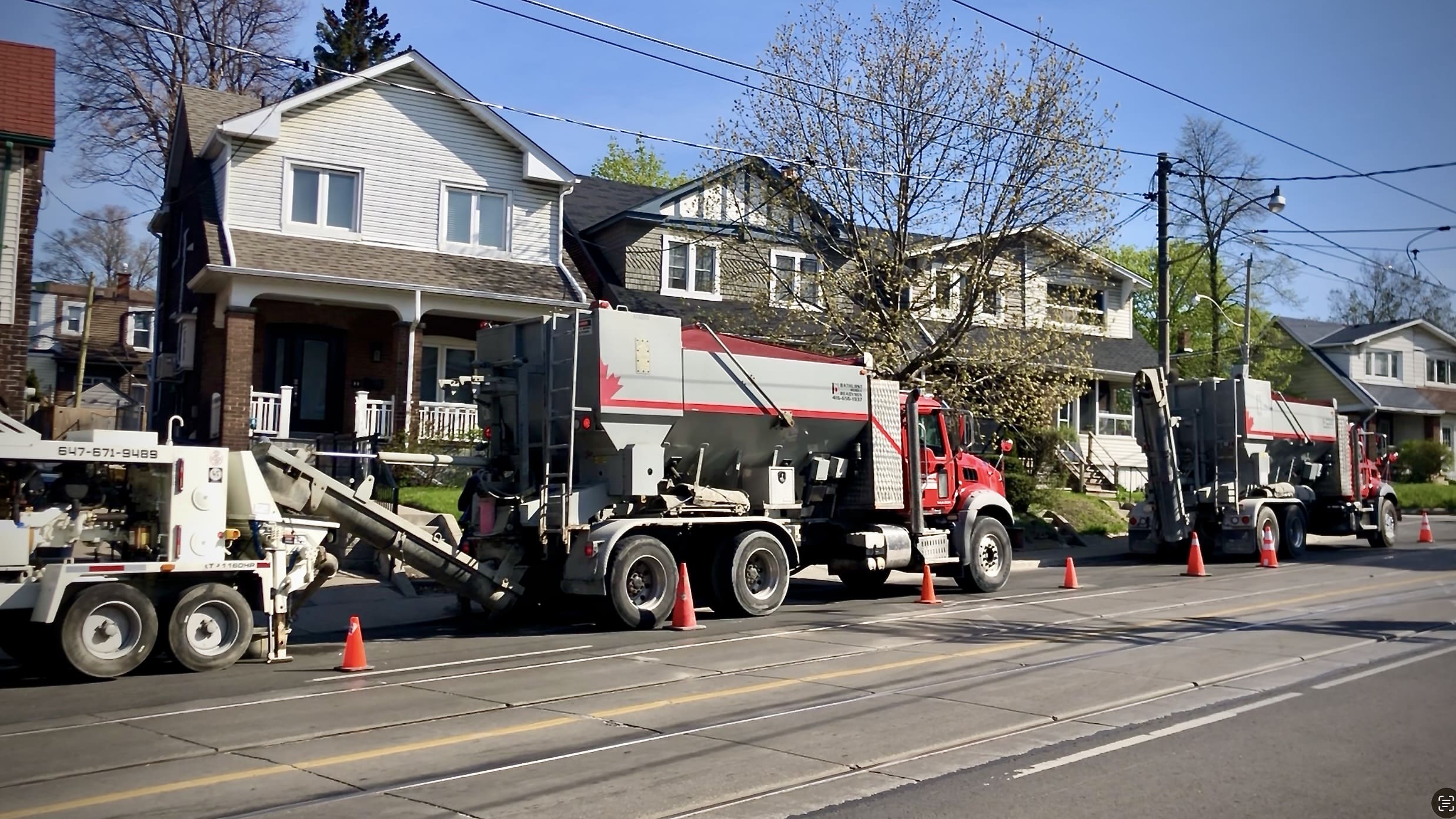 Asphalt paving trucks parked on residential street