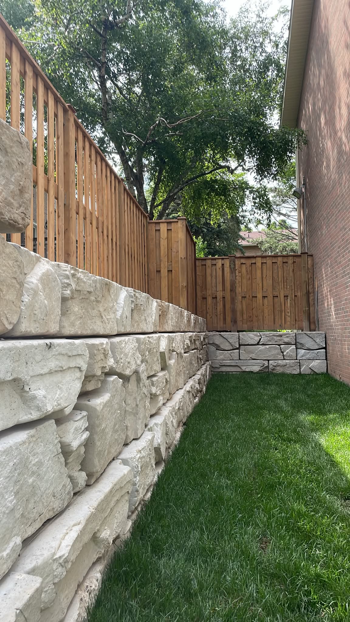 Narrow backyard with stone retaining wall